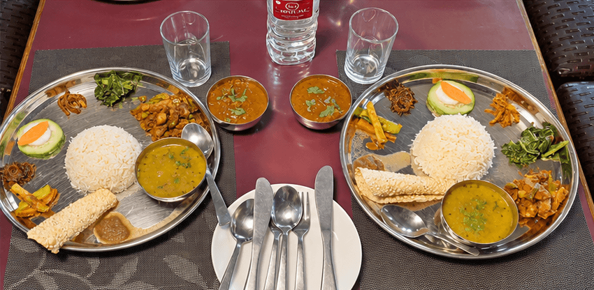Two Nepali thali sets at Hotel Taj with rice, dal, vegetables, pickles, and papad